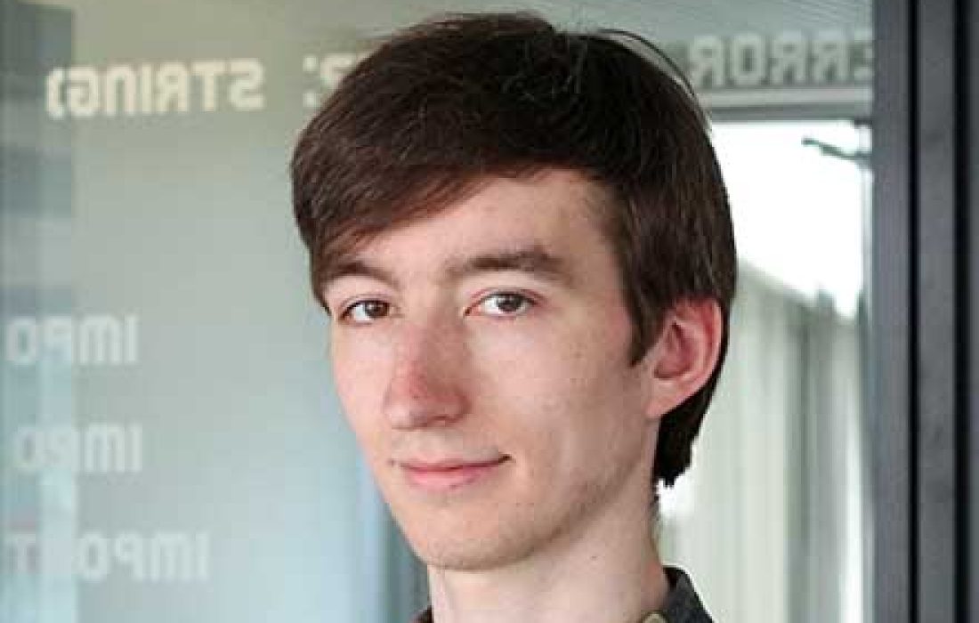 young brunette man with light skin looking into camera