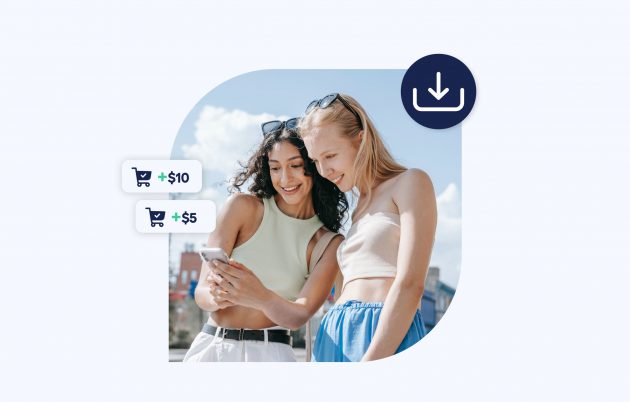 two young women outdoors smiling and looking at a phone