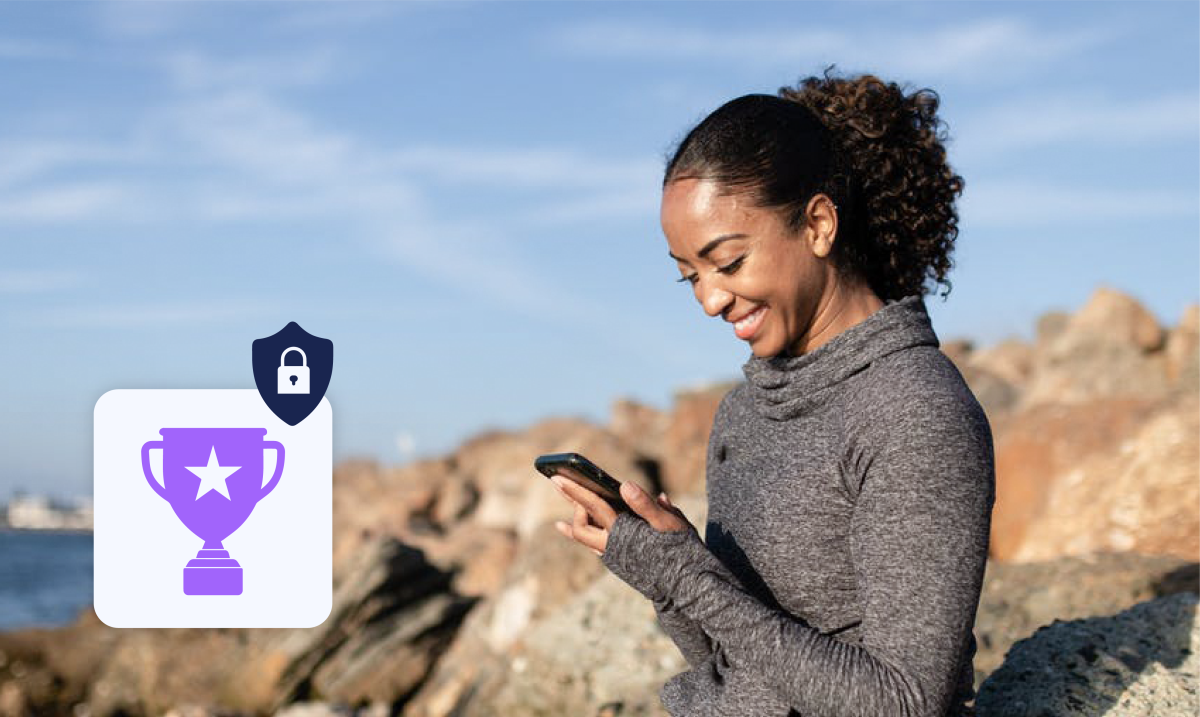 a young woman outside on her phone with a trophy and padlock symbol