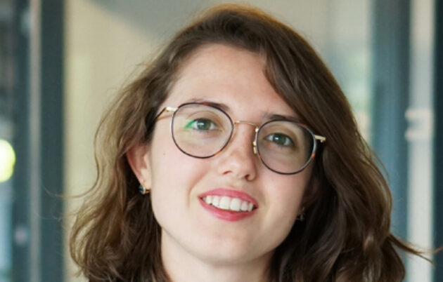 young brunette woman with glasses looking into camera