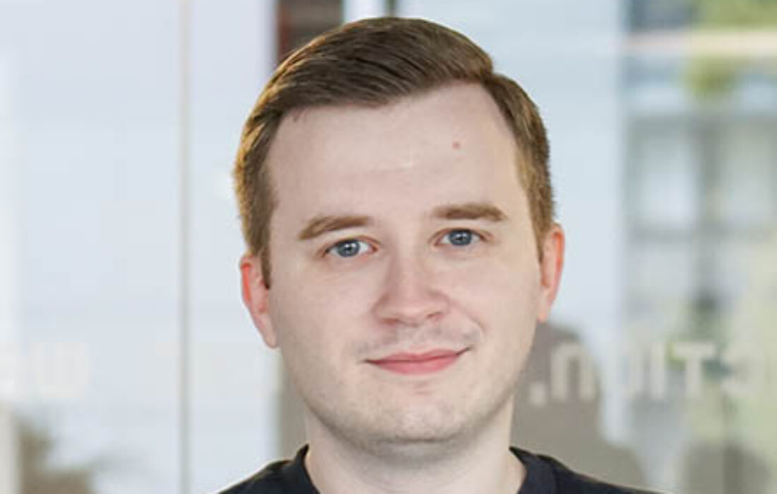 young pale man crossing arms and smiling at camera