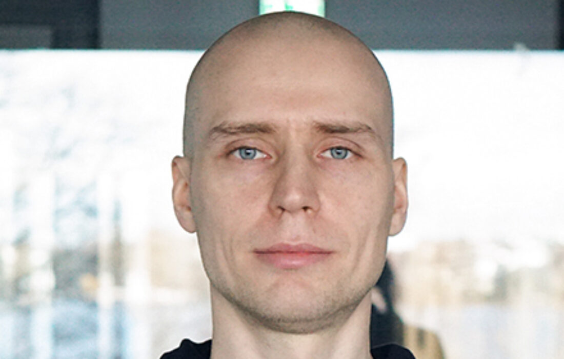 young bald man looking seriously into camera