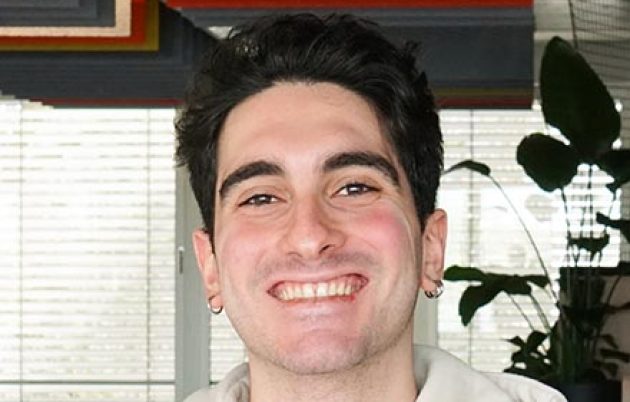 young dark-haired man smiling into camera