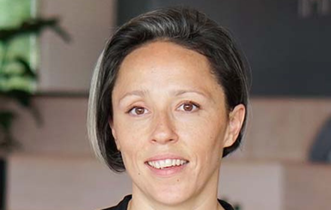 young woman with short hair smiling into the camera