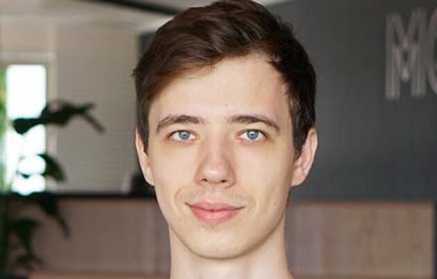 young fair-skinned man smiling into camera