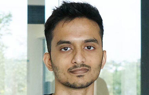 young man with dark hair looking into camera