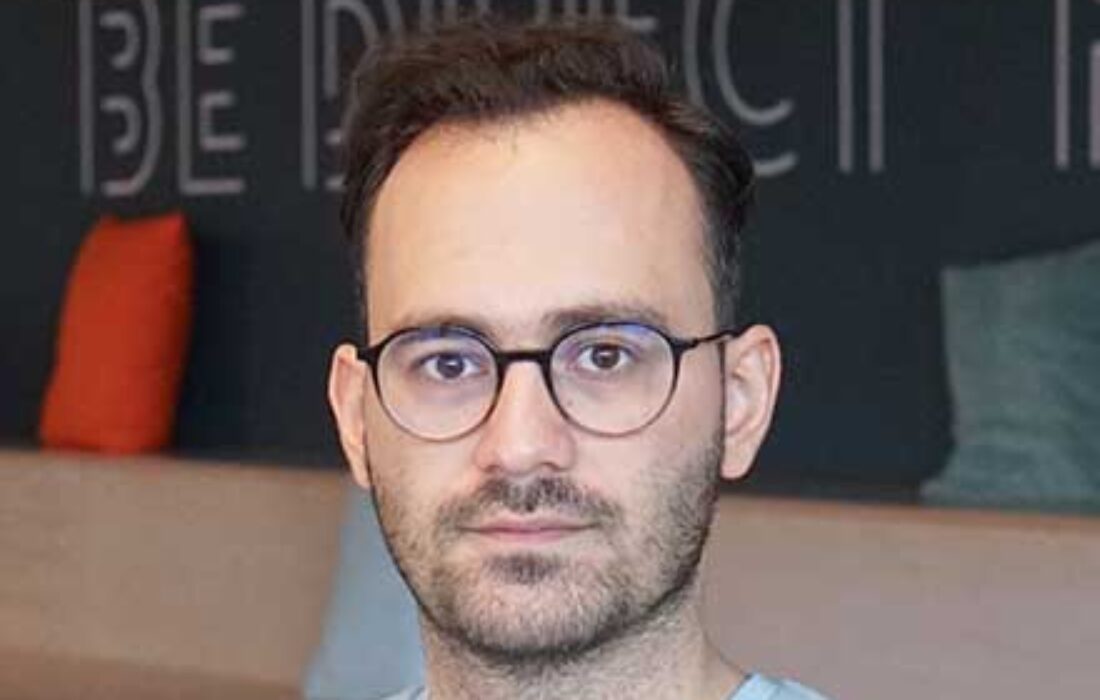 young man with glasses and light shirt looking at camera