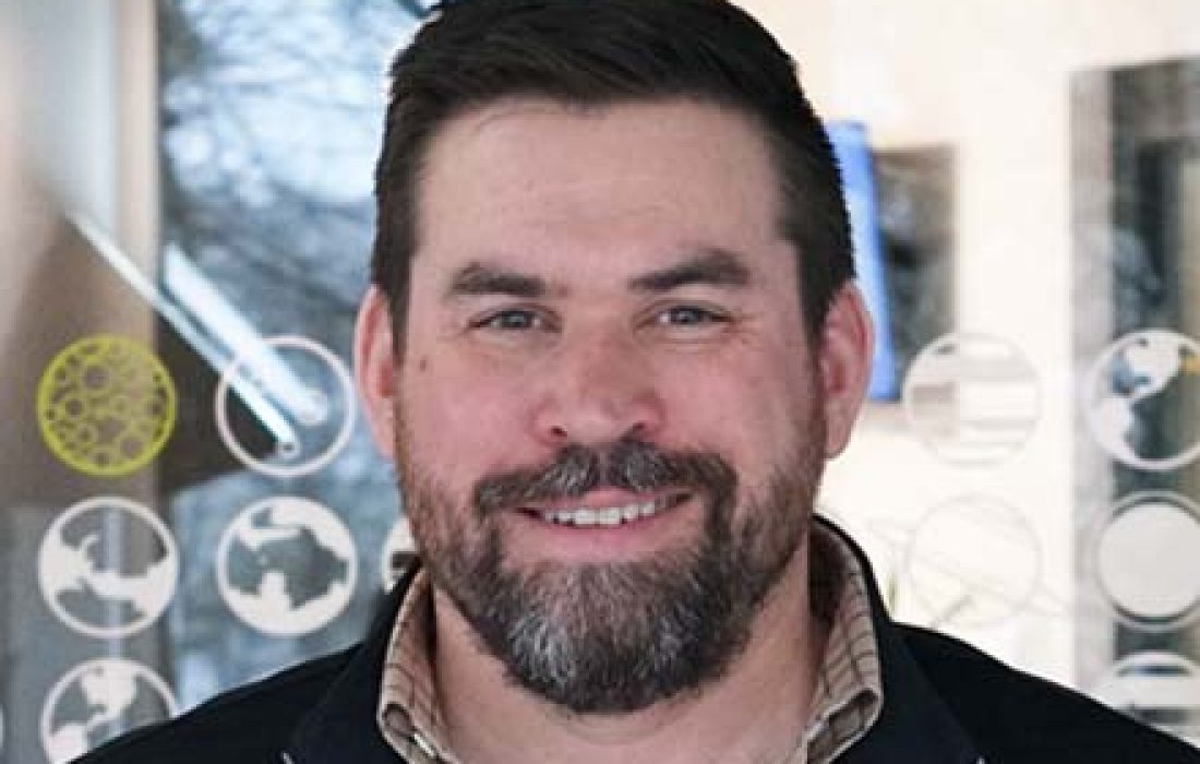 man smiling at the camera inside an office room