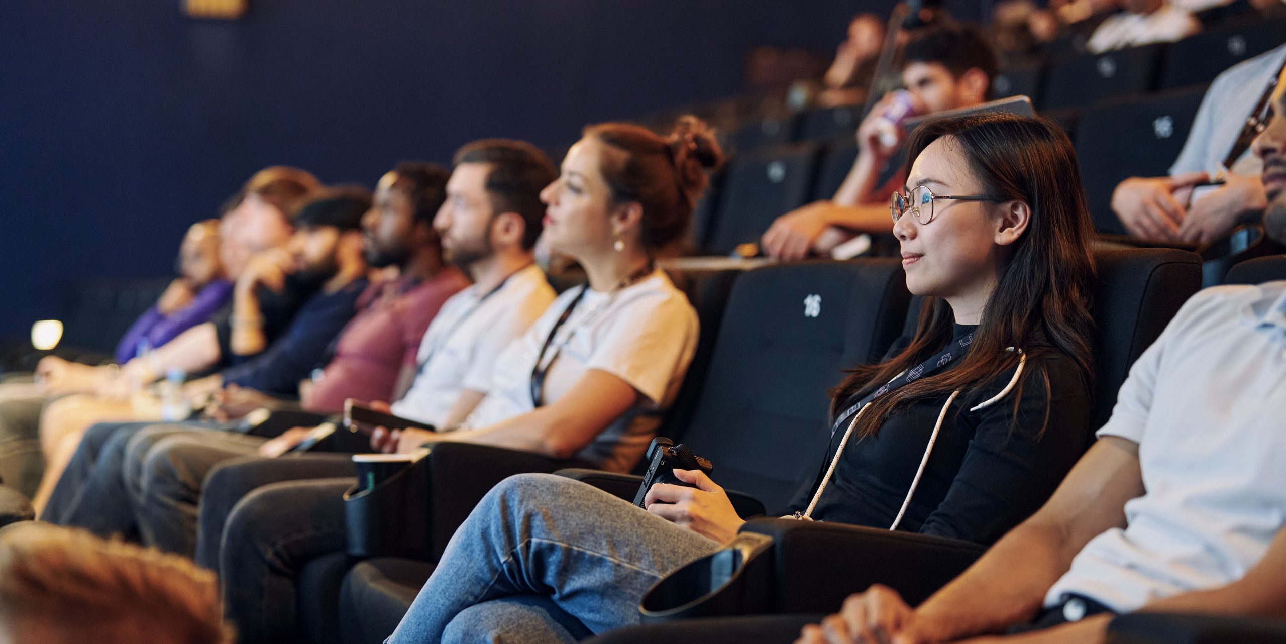 people in a movie theater at an adtech event looking straight ahead