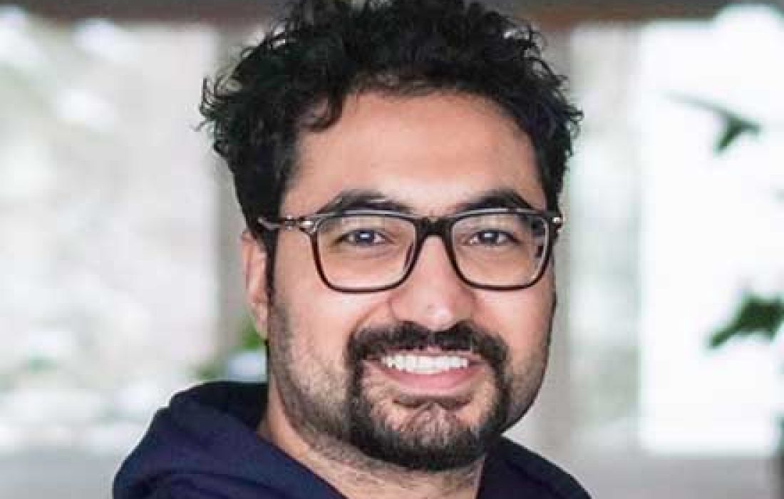 young man with glasses smiling at camera