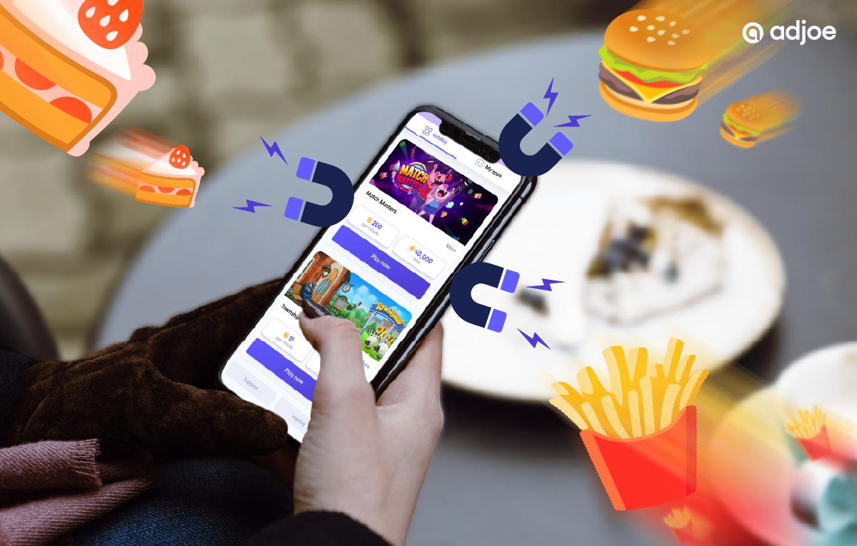 close-up of person holding phone with playtime offers and burger, chips icons as decorative elements