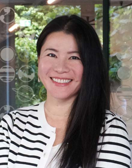 young woman in striped top smiling at camera