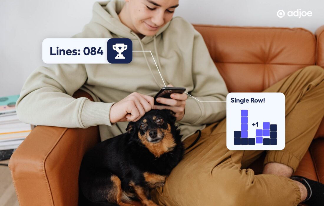 young person on a sofa with a dog on their lap looking at their phone while playing a game