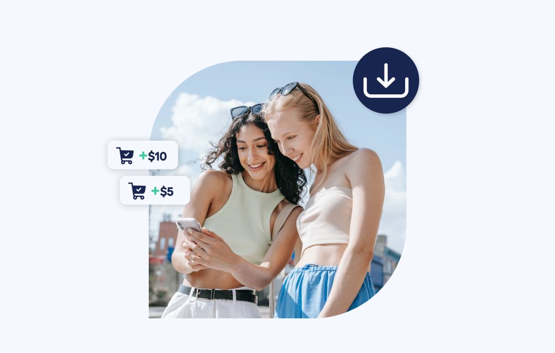 two young women outdoors smiling and looking at a phone