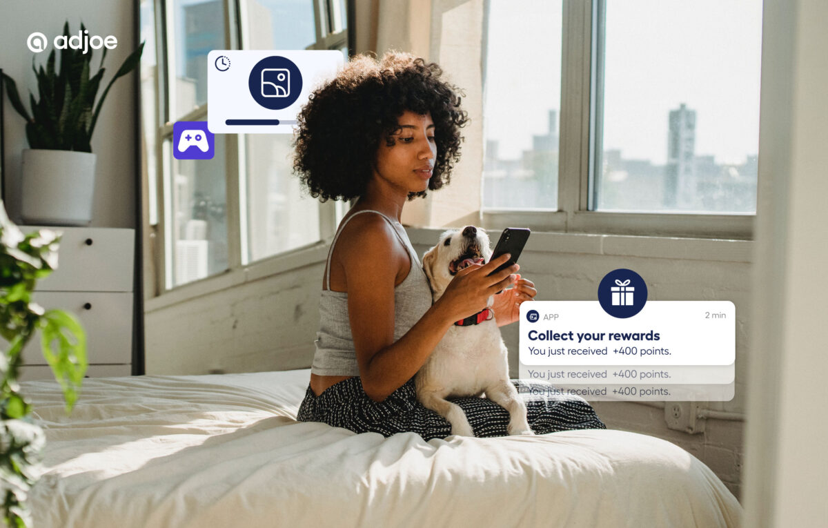young lady sitting on bed looking at her phone with decorative icons around her showing rewards