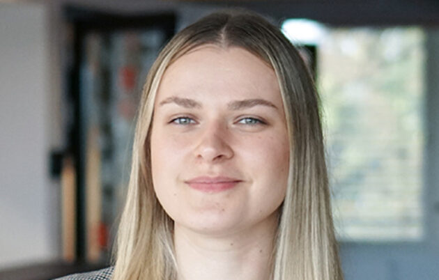 young blond woman with long hair smiling into camera
