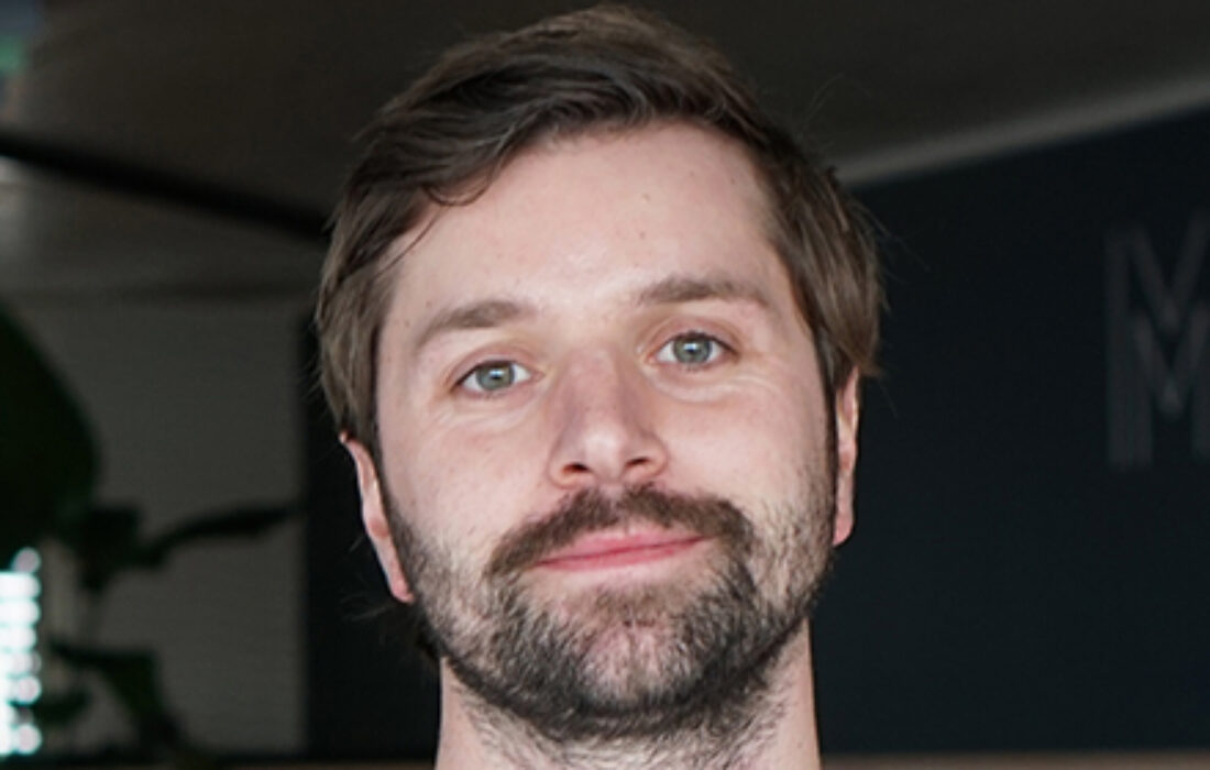 young bearded man smiling into camera