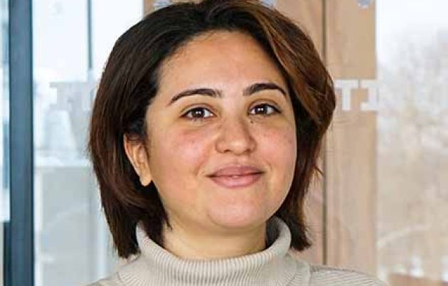 young woman in jumper and short hair smiling at camera