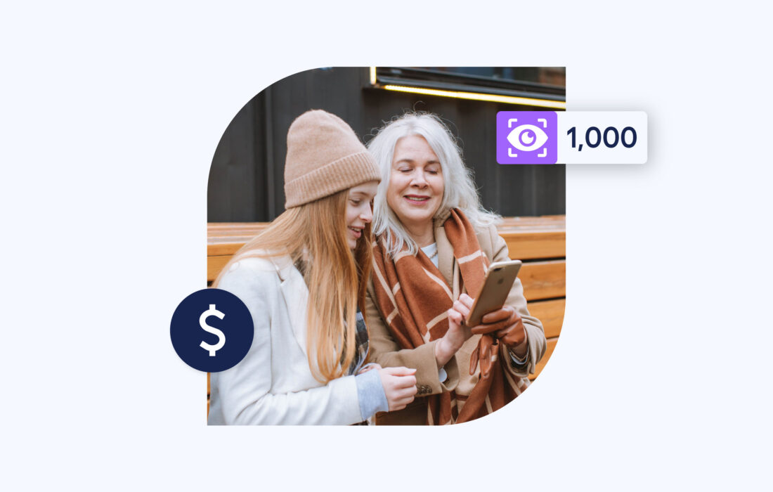 an elderly woman and younger woman outside sat down looking at a phone screen