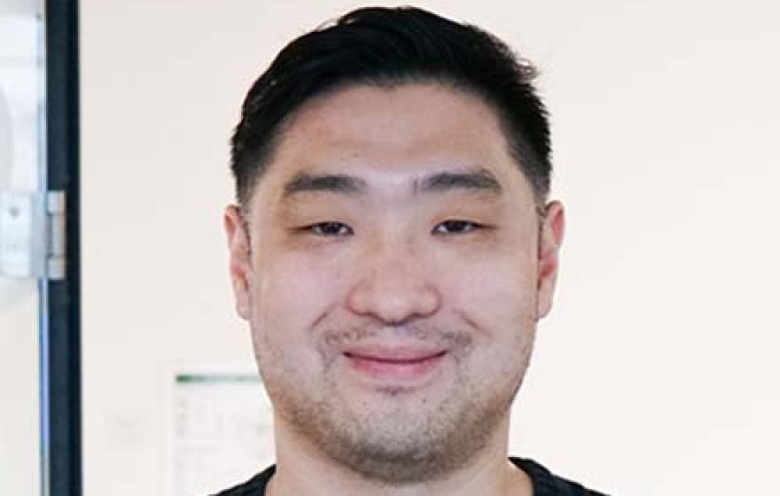young man with dark hair smiling at the camera