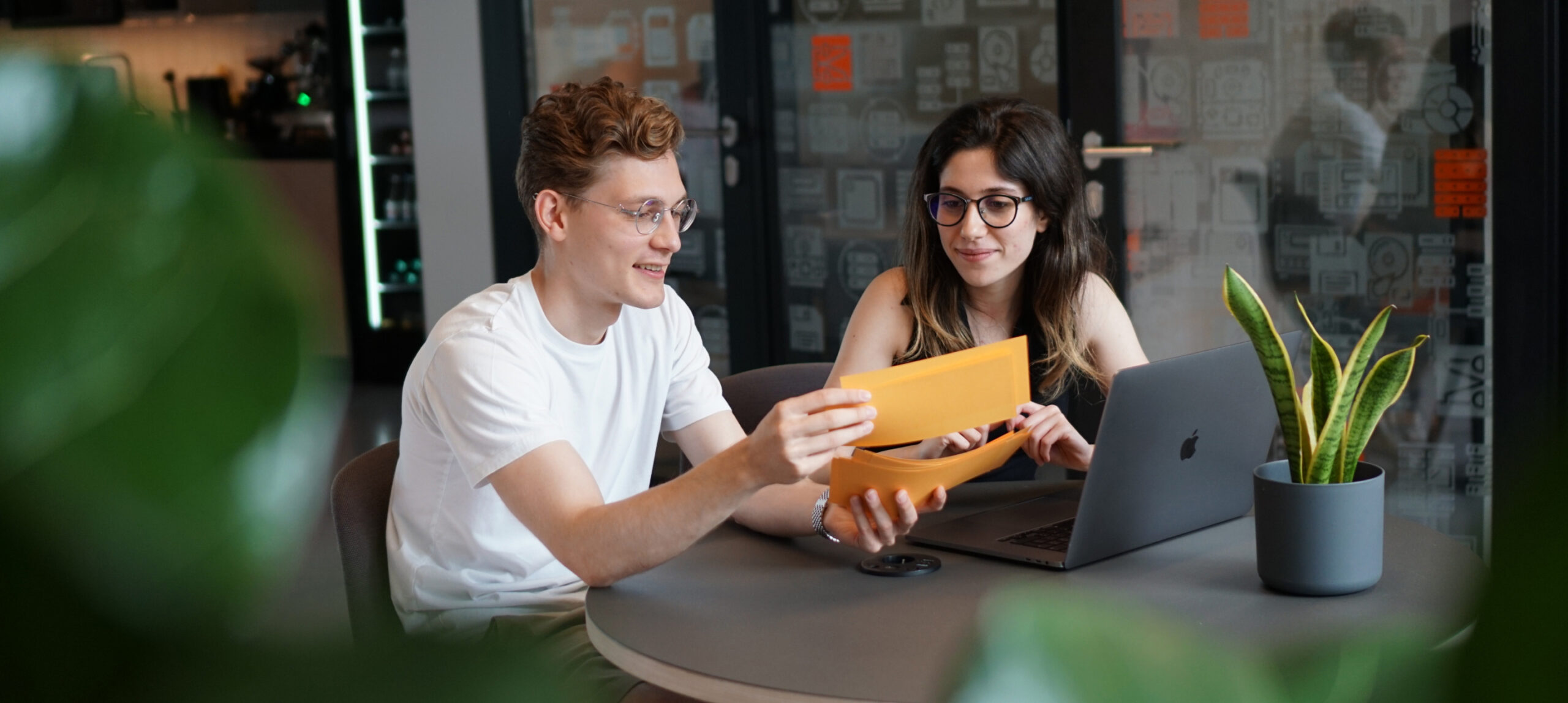 two young people sat down in an office working on engineers bog