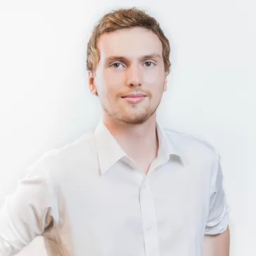 young man in white shirt smiling subtly at camera