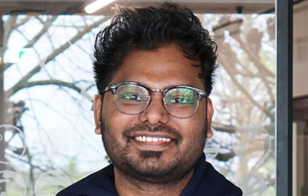 young man in branded hoodie smiling into the camera
