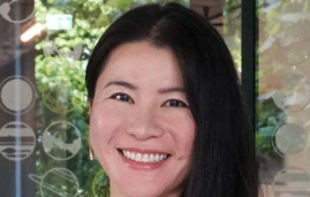 young woman in striped top smiling at camera